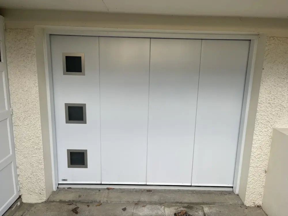 Porte sectionnelle latérale motorisée avec portillon - modèle MAESTRO